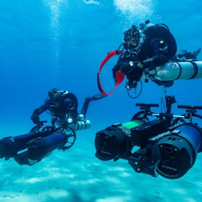 Due subacquei con DPV SUEX professionali su un fondale sabbioso