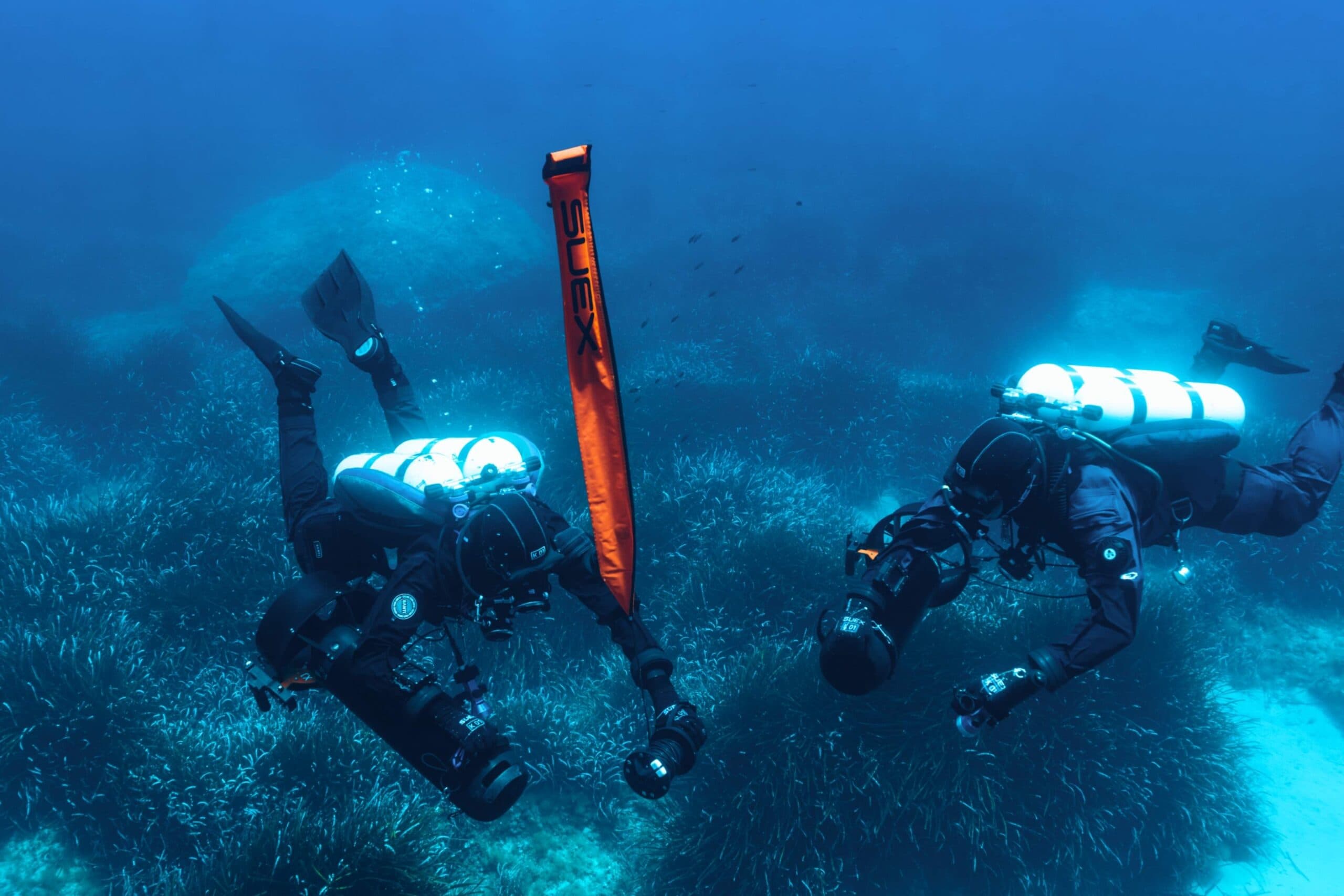 Due subacquei tecnici con DPV SUEX sulla prateria di posidonia, con boa di segnalazione SUEX rilasciata verso la superficie